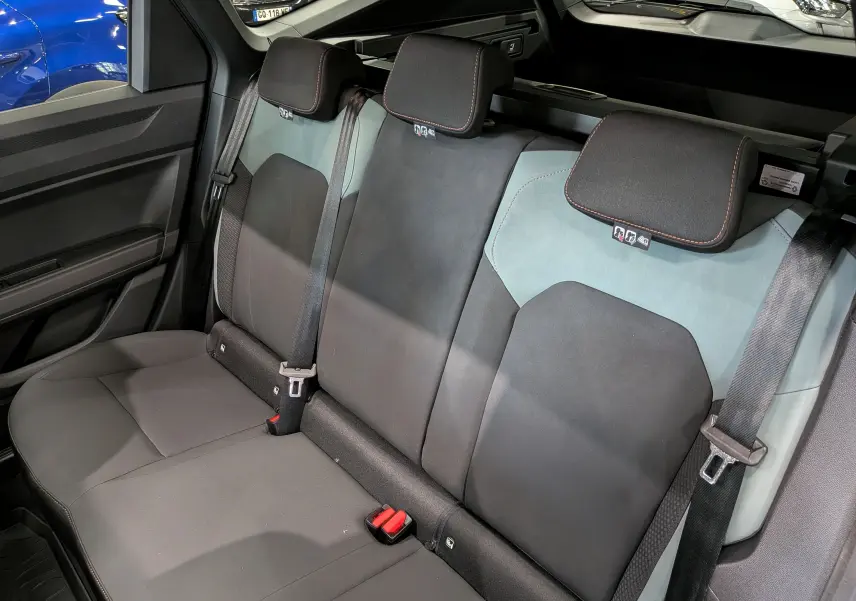 Vue intérieure de la banquette arrière du Dacia Bigster Hybrid-G 150 4x4, sièges bi-matière gris et noir avec ceinture de sécurité.