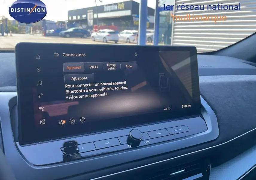 Écran tactile central du Nissan Qashqai 2025 gris céramique, affichant le menu de connexion Bluetooth en extérieur.