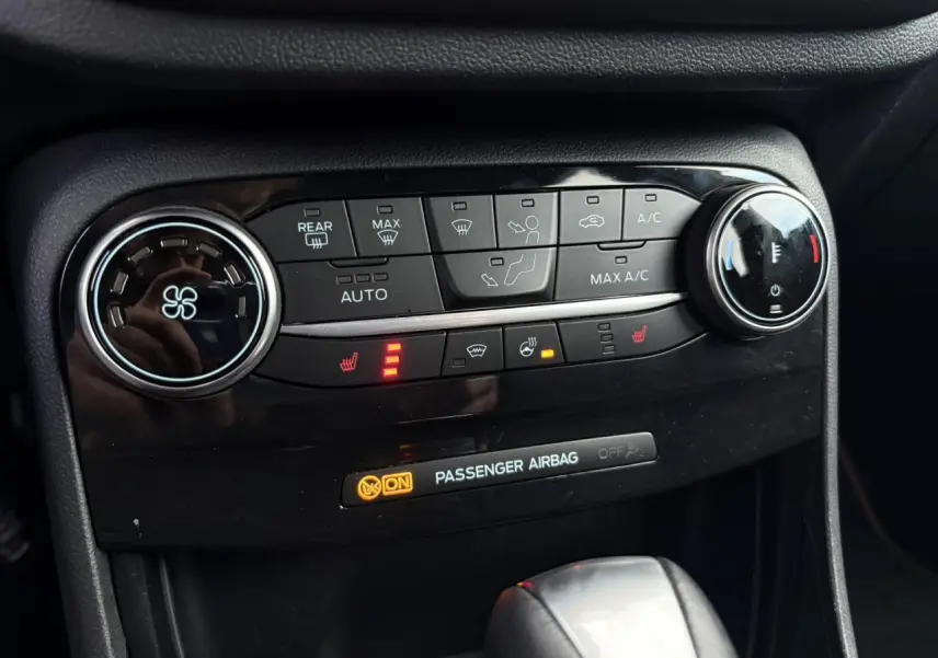 Détail de la console centrale du Ford Puma 2023 gris Solar, montrant les commandes de climatisation et sièges chauffants.