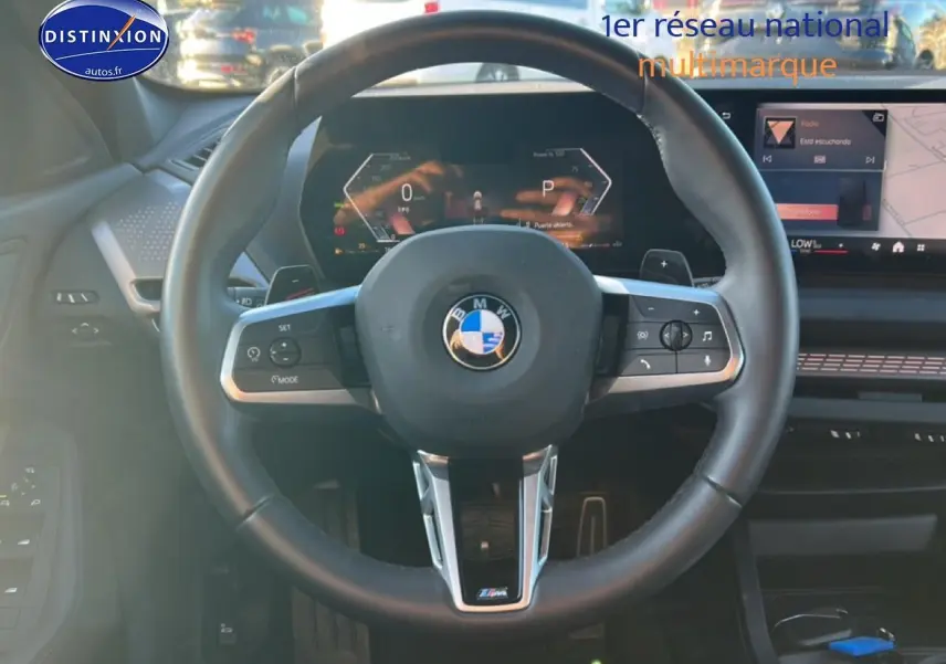 Vue centrée sur le volant cuir noir M Sport de la BMW Série 1 118da 2025 avec tableau de bord digital.