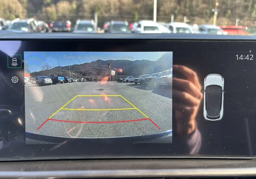 Affichage caméra de recul et vue 3D du toit noir sur l'écran intérieur du Kia Sportage blanc nacré 2026.