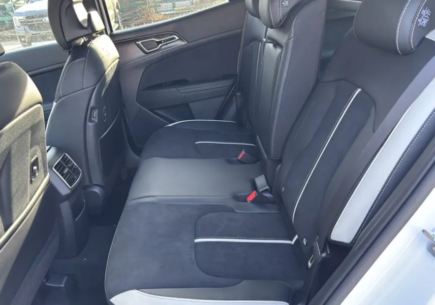 Vue côté gauche de la banquette arrière en cuir noir et alcantara avec surpiqûres blanches du Kia Sportage blanc nacré 2026.