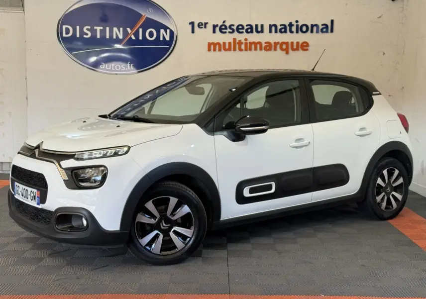 Citroën C3 blanche vue de profil droit, avec protections latérales noires et jantes bicolores distinctives.