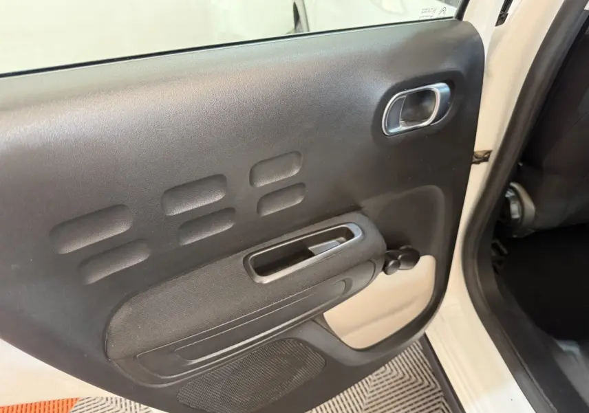 Vue intérieure de la porte arrière droite noire avec poignée et manivelle sur Citroën C3 blanc 2021.