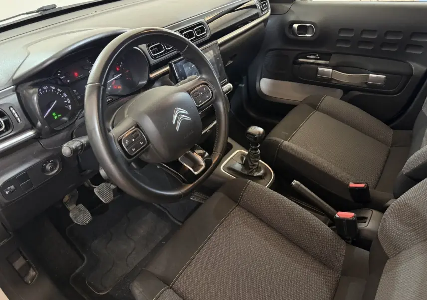 Intérieur de la Citroën C3 2021 vue côté conducteur, volant cuir multifonctions et levier de vitesse manuel visibles.