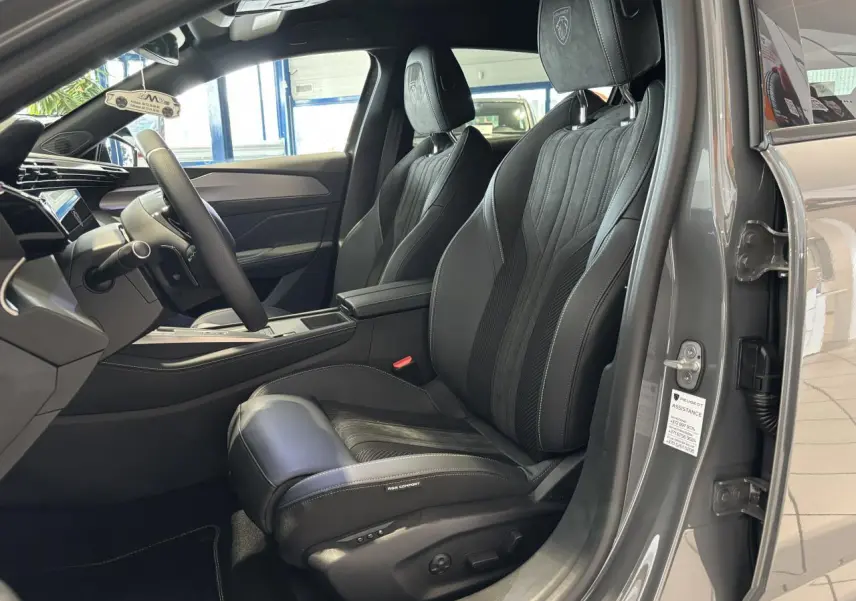 Vue intérieure côté conducteur de la Peugeot 308 gris selenium, sièges Alcantara noirs avec surpiqûres vert Adamite.