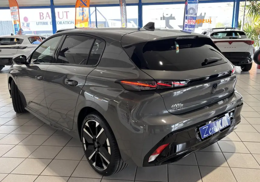 Vue 3/4 arrière droite d'une Peugeot 308 gris sélénium avec feux arrière LED 3 griffes et jantes alliage bi-tons.