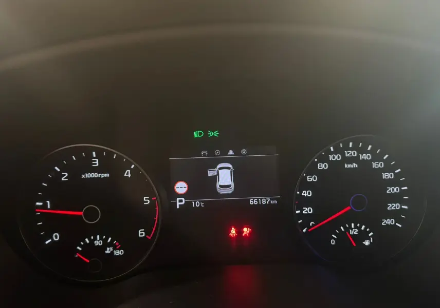 Tableau de bord du Kia Sportage 2019 avec compte-tours, compteur de vitesse, écran central indiquant porte ouverte et 66 187 km.