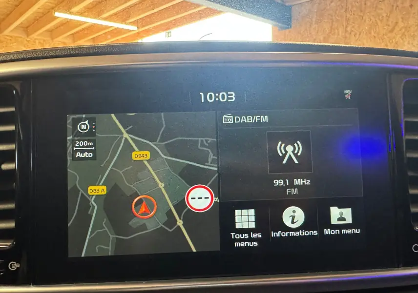 Écran tactile du système de navigation et radio DAB/FM affichant une carte et fréquence 99,1 MHz dans un Kia Sportage.