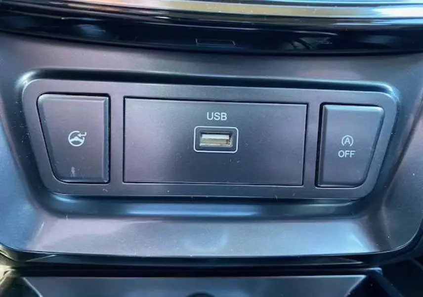 Gros plan sur la prise USB et boutons de commande noirs dans l'habitacle du SsangYong Tivoli gris foncé.
