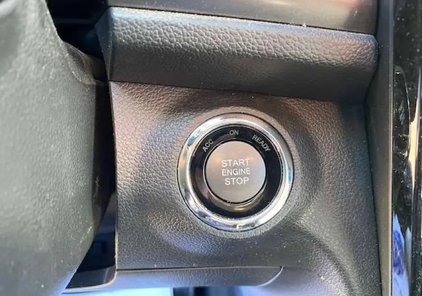 Gros plan sur le bouton Start Engine Stop entouré de chrome dans l'habitacle du SsangYong Tivoli 2021 gris foncé.