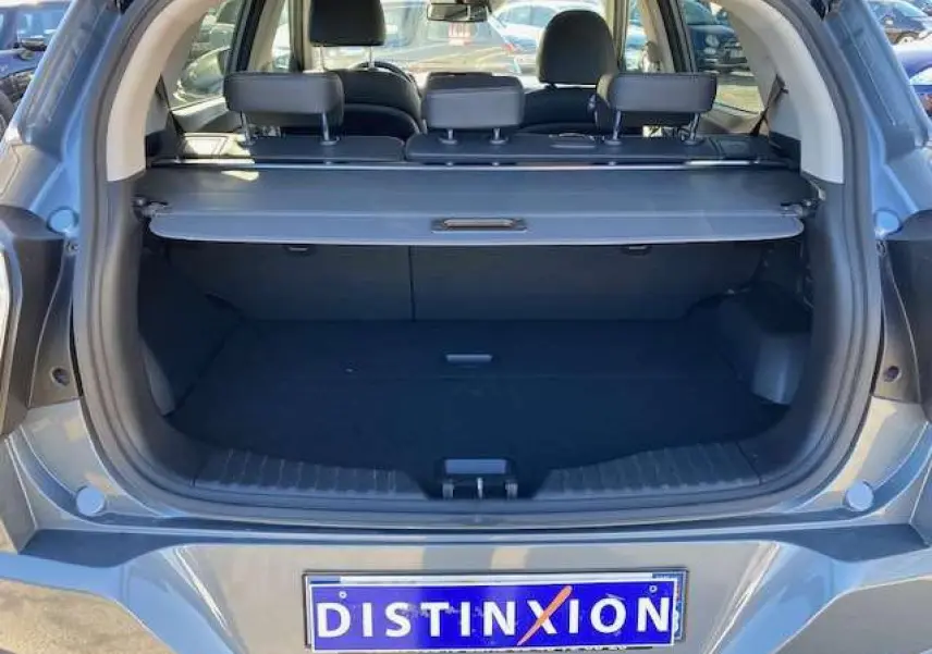 Coffre ouvert vu de l'arrière d'un SsangYong Tivoli gris foncé, montrant l'espace de chargement et les appuie-têtes arrière.
