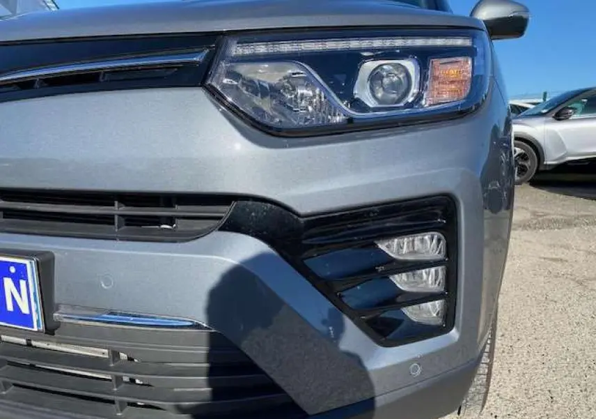 Gros plan sur l’avant droit gris foncé du SsangYong Tivoli 2021, mettant en valeur ses phares LED et la calandre noire.