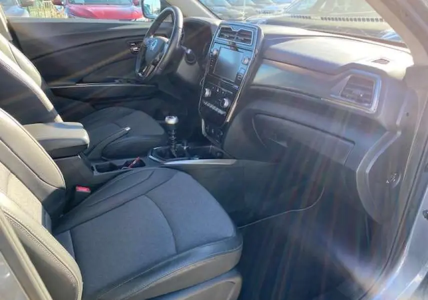 Vue intérieure côté conducteur du SsangYong Tivoli 2021, montrant sièges noirs, volant cuir et console centrale avec écran tactile.