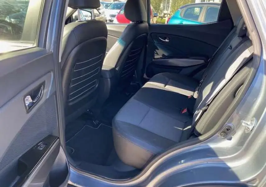 Vue côté gauche arrière du SSANGYONG TIVOLI gris foncé montrant l'intérieur des sièges arrière et la portière ouverte.
