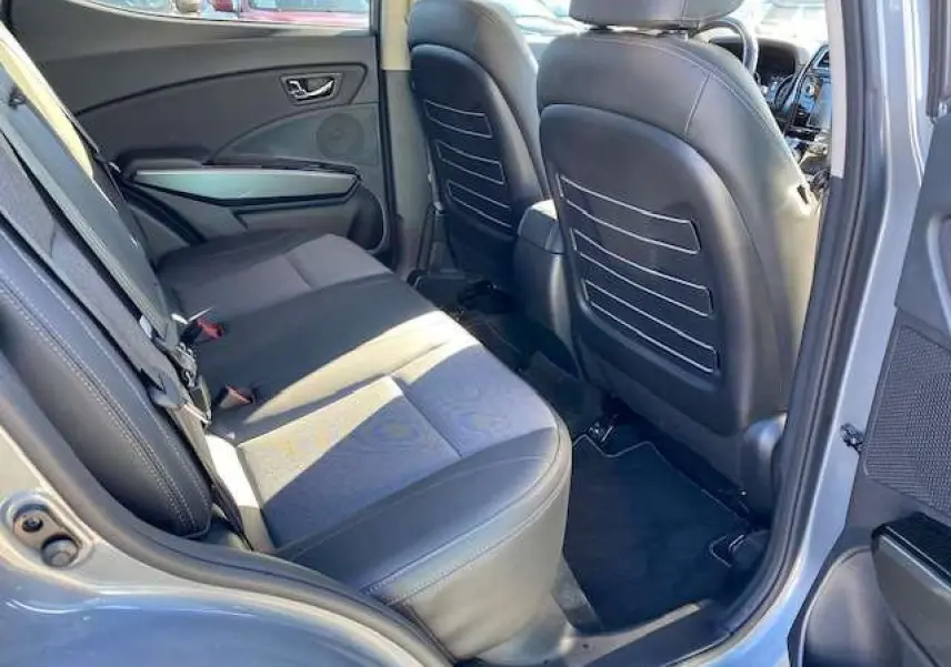 Vue intérieure arrière droite du SsangYong Tivoli gris foncé 2021, montrant les sièges et panneaux de porte en cuir noir.