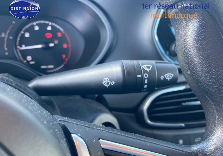 Gros plan sur la commande d’essuie-glace à gauche du volant dans l’habitacle d’une Fiat Tipo bleu 2024.