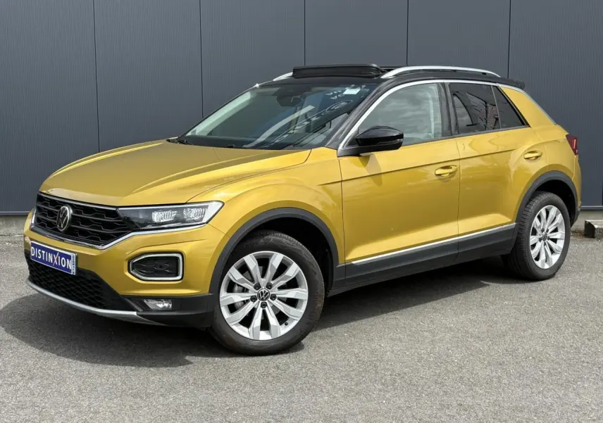 Volkswagen T-Roc jaune curcuma vue 3/4 avant droit avec toit ouvrant noir et jantes alliage 17 pouces.