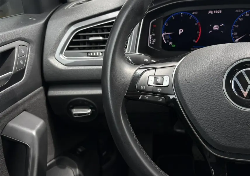 Vue rapprochée du volant multifonction noir et du tableau de bord digital du Volkswagen T-Roc 1.5 TSI 2021.