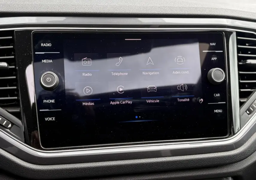 Vue rapprochée de l'écran tactile central du Volkswagen T-Roc 1.5 TSI 2021, affichant les options multimédia et navigation.