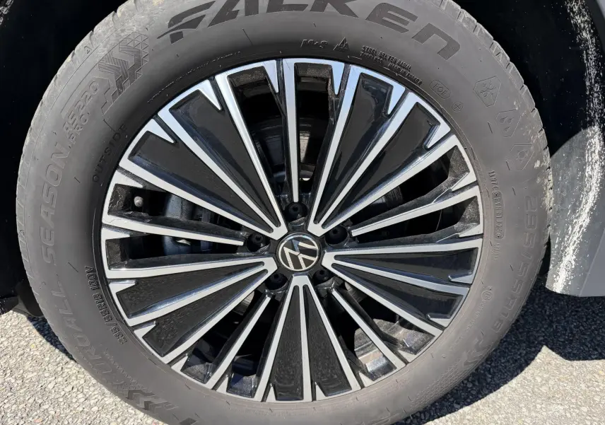 Gros plan sur la jante alliage 18 pouces Napoli noire et argentée du Volkswagen Tiguan bleu, avec pneu Falken 235/55 R18.