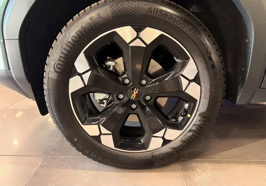 Gros plan sur la jante bi-ton noire et argent d’un Dacia Bigster Hybrid-G 150 4x4 Vert Cèdre, roue avant droite.