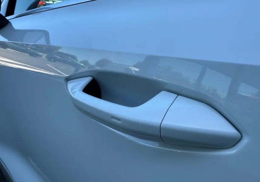 Poignée de porte blanche Glacier métallisé en gros plan sur le côté gauche d'une Audi A3 Sportback 2025.