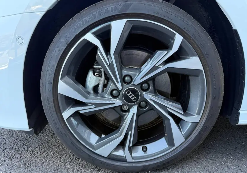 Gros plan sur la jante alu gris anthracite à design sportif de l'Audi A3 Sportback blanc glacier métallisé, roue avant droite.