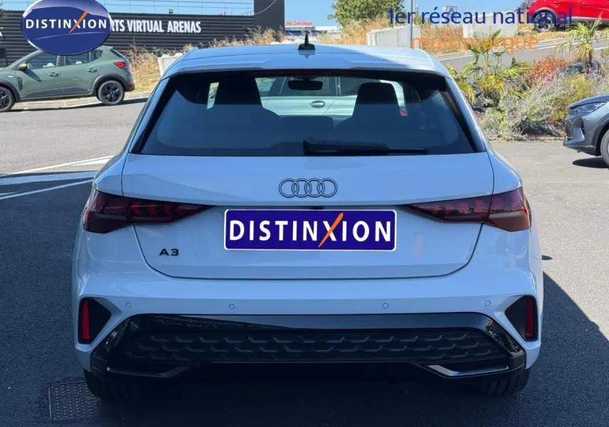 Vue arrière d'une Audi A3 Sportback blanche Glacier métallisé, avec feux LED et diffuseur noir sportif.