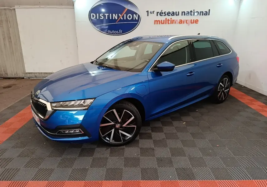 Vue 3/4 avant droite d'une Skoda Octavia Style hybride rechargeable bleu métallisé avec jantes noires et grises.
