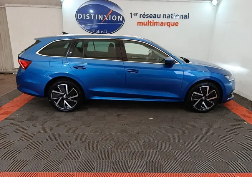 Vue latérale droite d'une Skoda Octavia break bleu 2022 avec jantes noires et détails chromés sur les vitres.