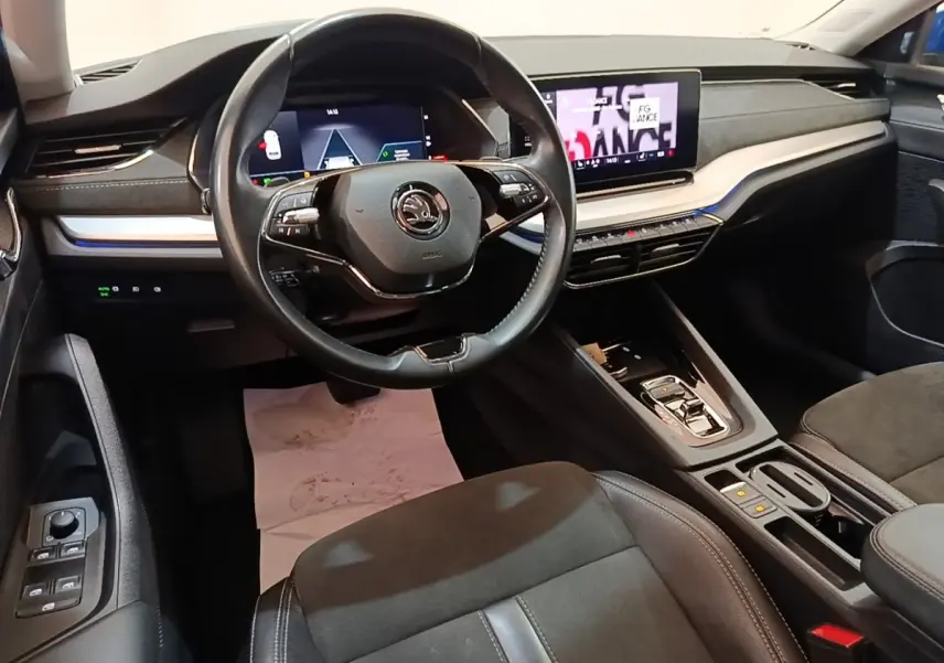 Vue intérieure avant droite du poste de conduite de la Skoda Octavia hybride rechargeable avec volant cuir et écran tactile central.