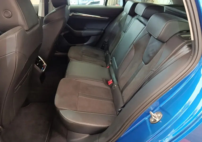 Vue côté droit de la banquette arrière en cuir et alcantara d'une Skoda Octavia bleu 2022, porte ouverte.
