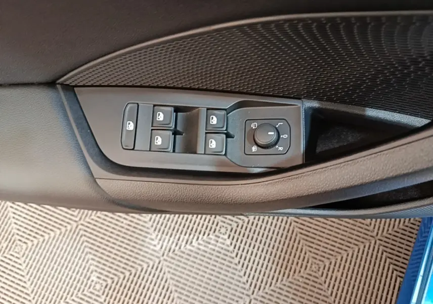 Commandes des vitres et réglage des rétroviseurs sur la porte côté conducteur d'une Skoda Octavia bleu 2022.