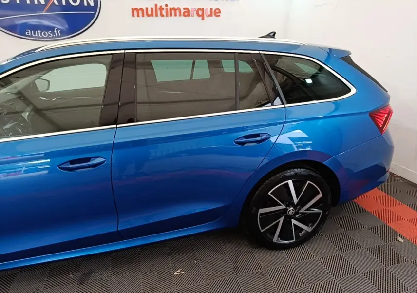 Vue latérale gauche d'une Skoda Octavia bleue 2022, mettant en valeur les jantes noires et les vitres teintées.