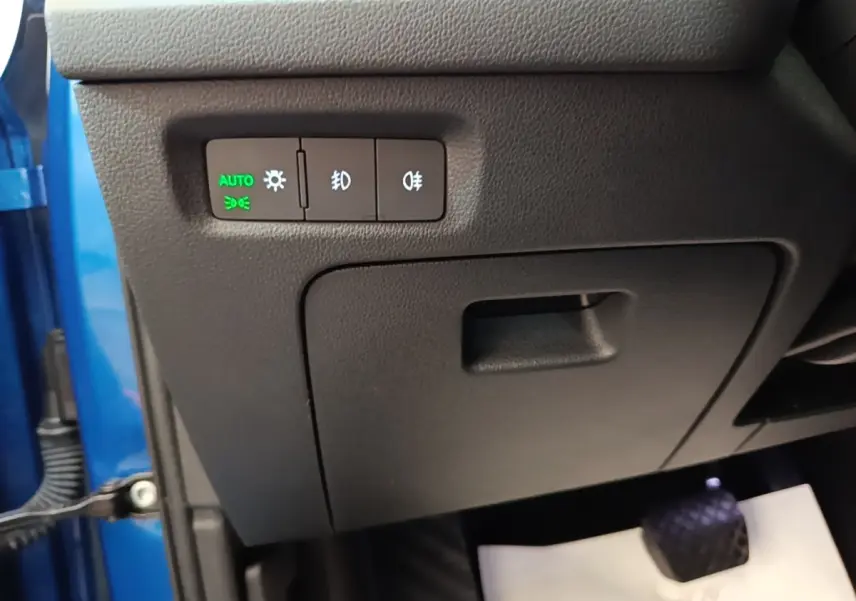 Détail du panneau de commande des phares à gauche du volant dans une Skoda Octavia bleue 2022, version hybride rechargeable.