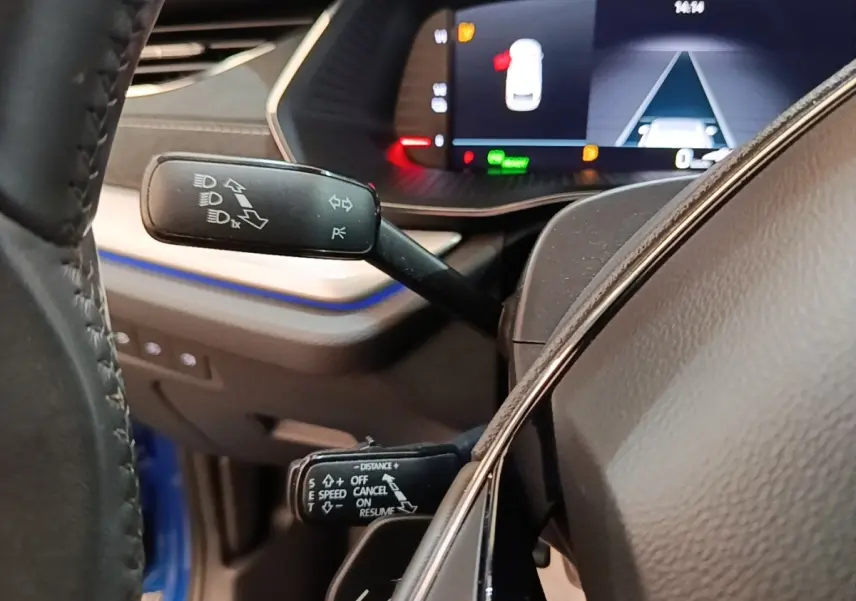 Gros plan sur les commandes au volant d’une Skoda Octavia 1.4 TSI PHEV 2022, intérieur avec tableau de bord numérique.