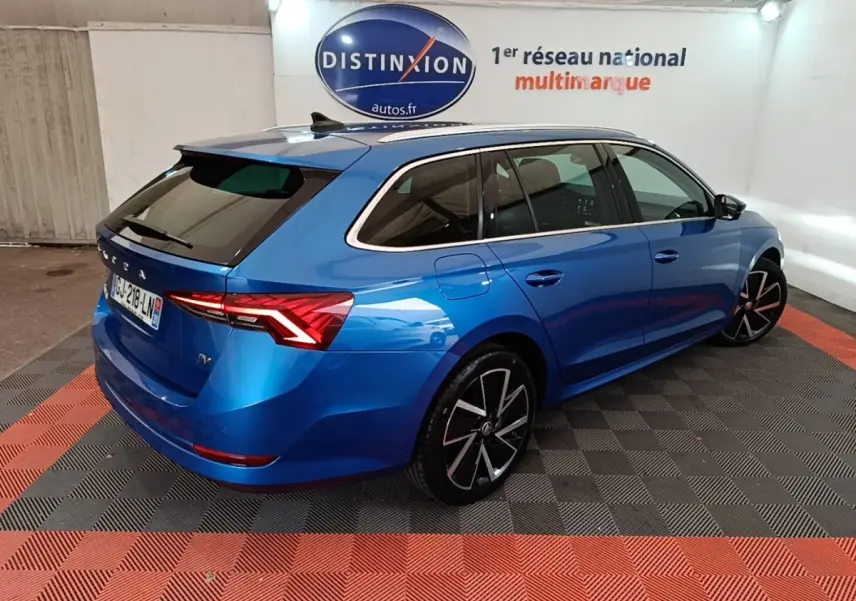Vue 3/4 arrière droite d'une Skoda Octavia bleue hybride rechargeable, avec jantes noires et feux LED distinctifs.