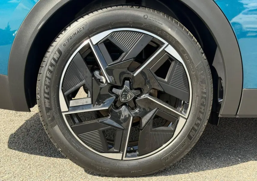 Gros plan sur la jante alu noire et argentée du côté avant droit d'une Peugeot 408 Hybrid Bleu Obsession.