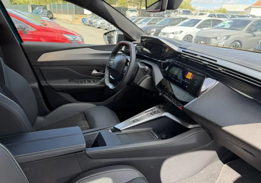 Intérieur avant droit du Peugeot 408 Hybrid bleu, avec tableau de bord numérique et console centrale moderne.