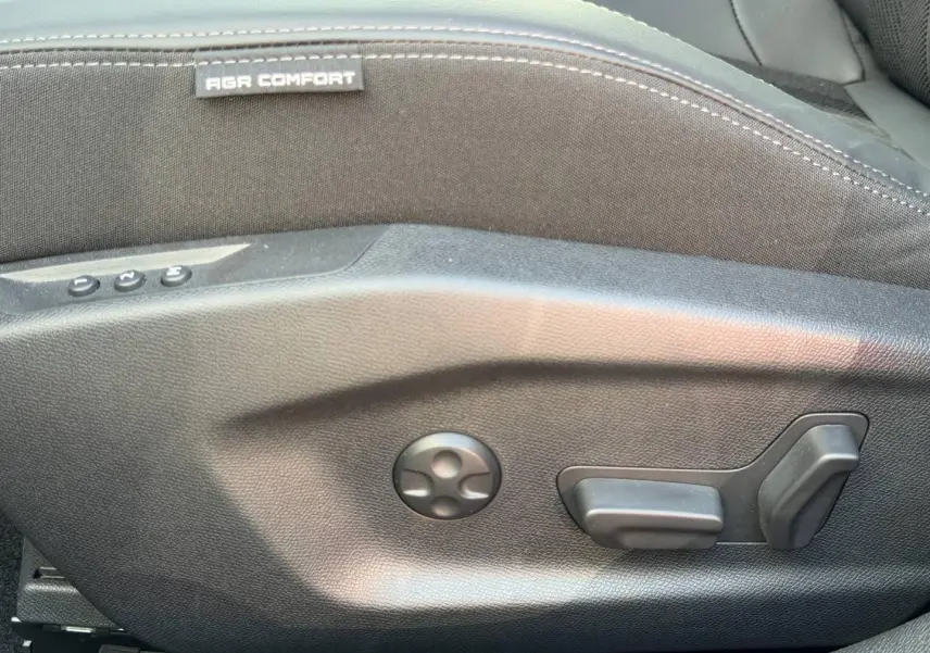 Détail des commandes de réglage électrique du siège conducteur noir de la Peugeot 408 Hybrid 145ch GT.