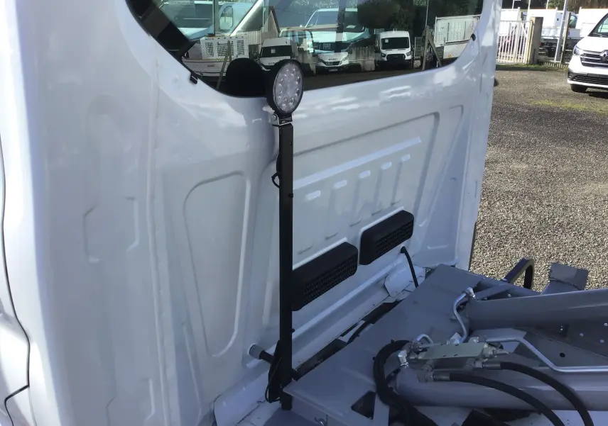Détail du bras polybenne blanc du Ford Transit Chassis Cabine vu de près, montrant les vérins et la structure métallique.