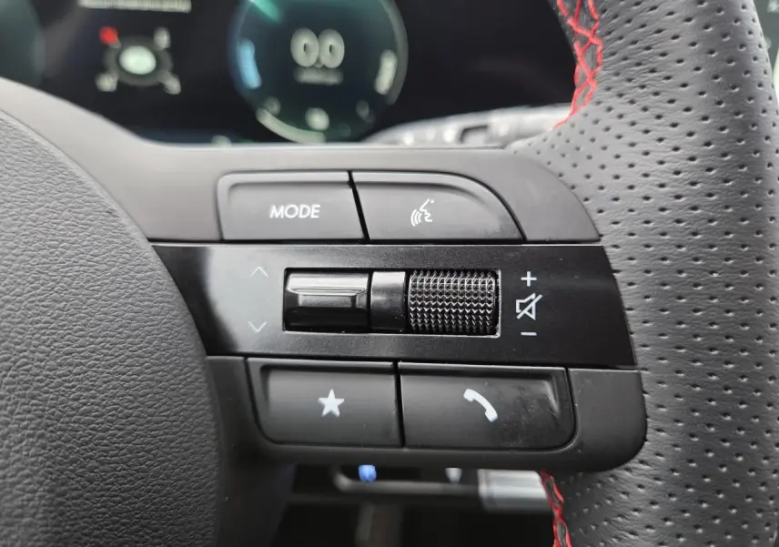 Gros plan sur les commandes gauche du volant perforé noir avec surpiqûres rouges du Hyundai Tucson 2025 N Line.