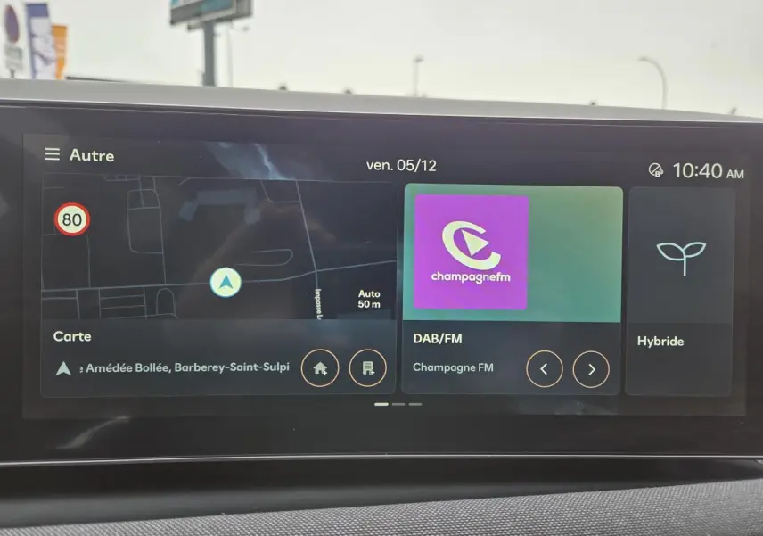 Écran tactile intérieur du Hyundai Tucson 2025 affichant navigation, radio DAB et mode hybride.