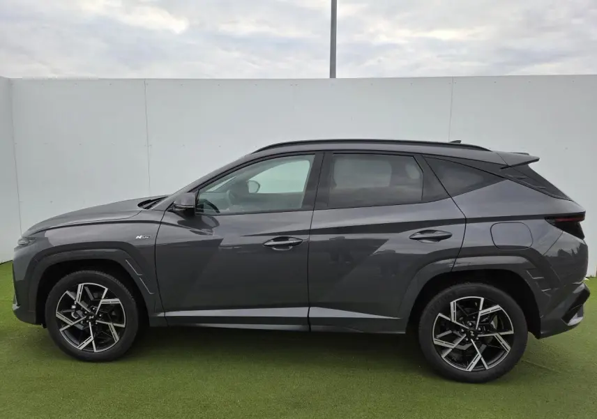 Profil droit du Hyundai Tucson 2025 gris métallisé avec jantes alliage et badge N Line visible sur l'aile avant.
