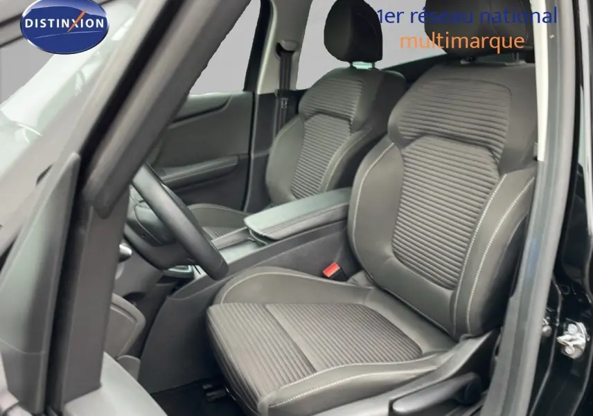 Vue intérieure côté conducteur du Renault Grand Scenic noir étoile métal, sièges tissu et cuir avec surpiqûres blanches.