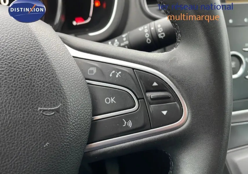 Gros plan sur le volant noir du Renault Grand Scenic 2022, montrant les commandes multifonctions côté droit.