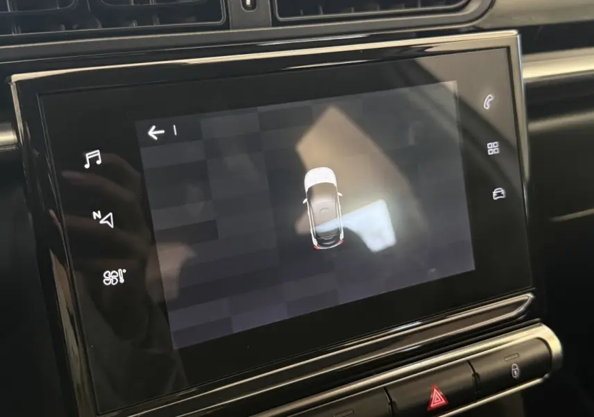 Écran tactile central affichant la vue aérienne d'une Citroën C3 blanche, intérieur noir moderne.