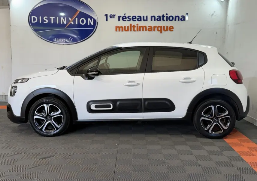 Vue de profil côté gauche d'une Citroën C3 blanche 2021 avec protections noires sur les portières et jantes alliage.
