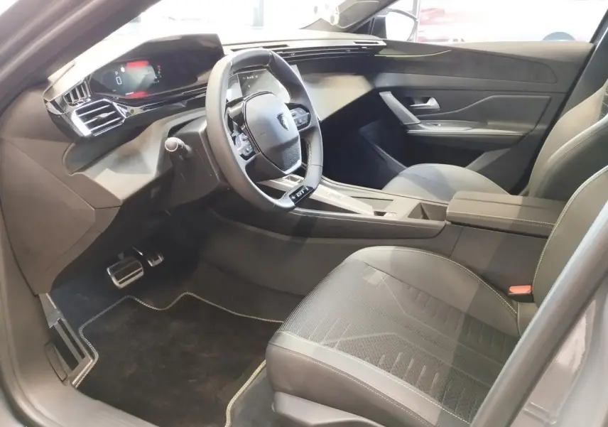 Intérieur avant droit de la Peugeot 308 gris Selenium, volant compact GT cuir et tableau de bord numérique 10 pouces.